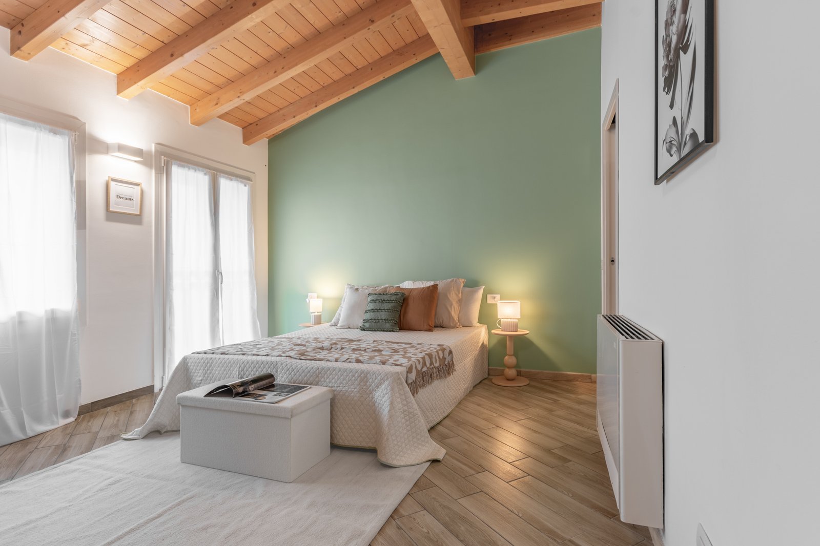 3_home-staging-camera-letto-mansarda-travi-legno-salvia-accogliente.jpg Camera da letto matrimoniale mansardata dal carattere elegante, con travi in legno a vista e parete color salvia, atmosfera accogliente e rilassante, con complementi in tonalità beige, salvia e senape.