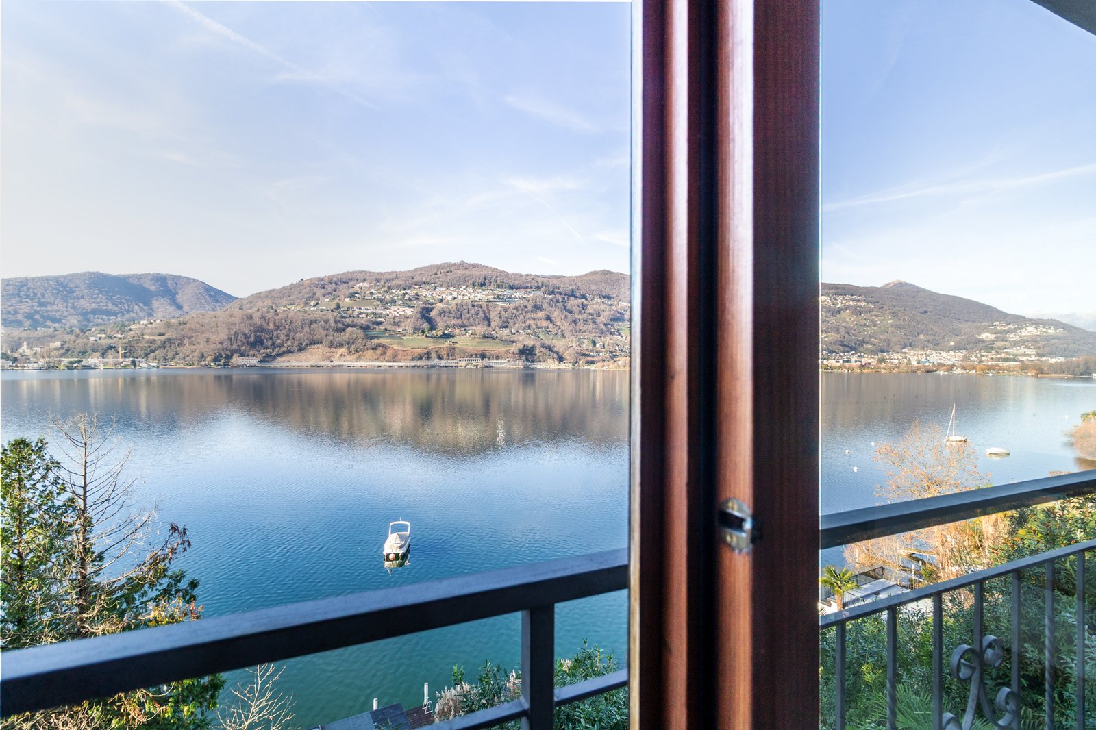 5_vista-panoramica-lago-balcone-appartamento-design.jpg Vista panoramica dal balcone sul lago e montagne, atmosfera serena e luminosa.